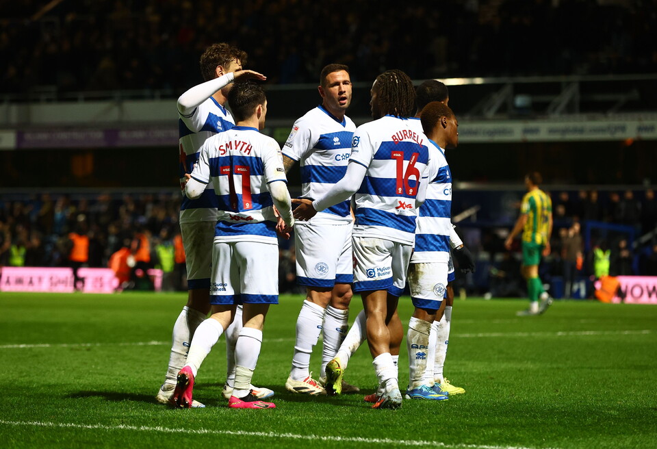 QPR players celebrate a goal scored against WBA in their home kit 