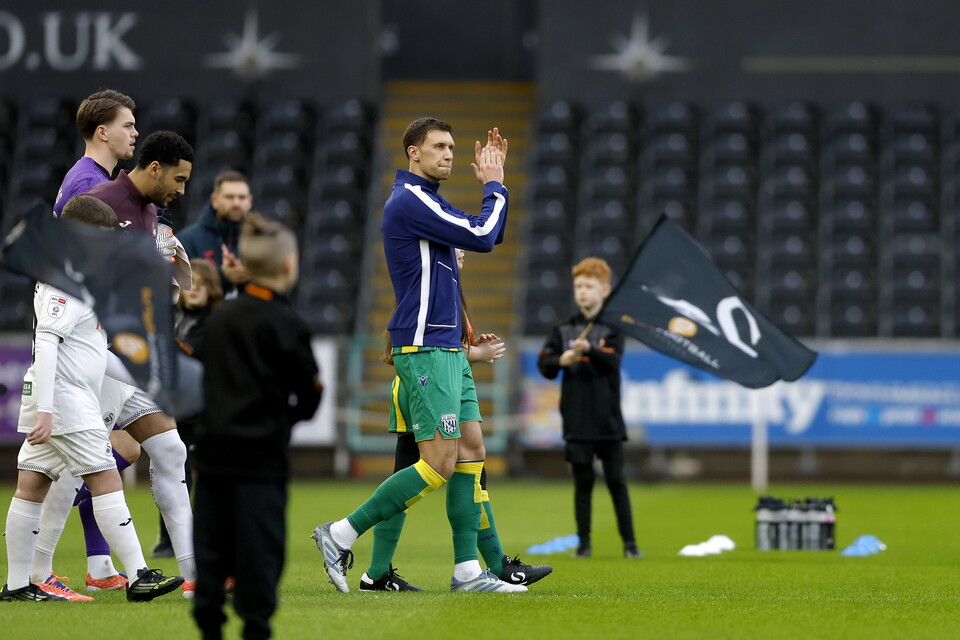 Krystian Bielik claps the Albion fans in Swansea.