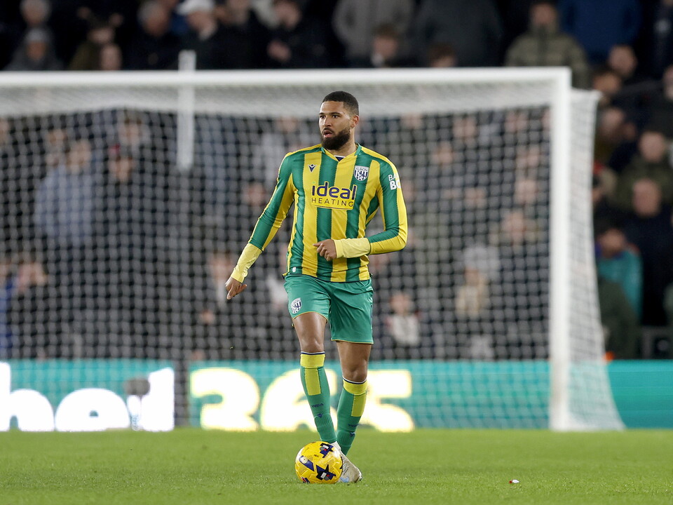A photo of defender George Campbell, in the 2025/26 green and yellow away kit, in action against Derby