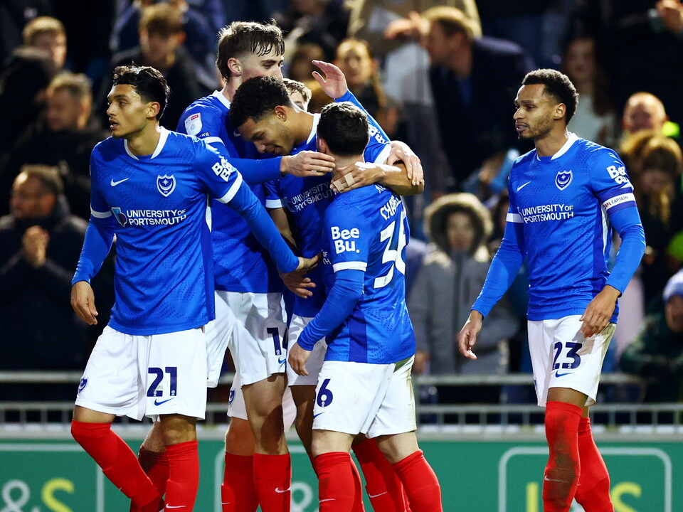 Portsmouth players celebrate a goal scored in their home kit 