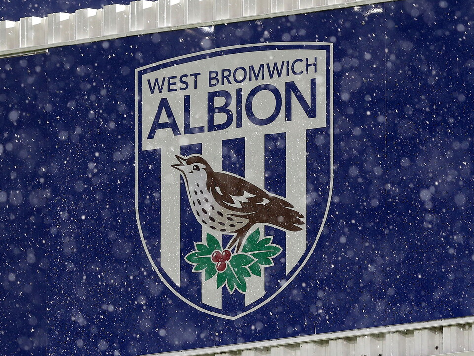 An image of snow falling in front of the Albion badge