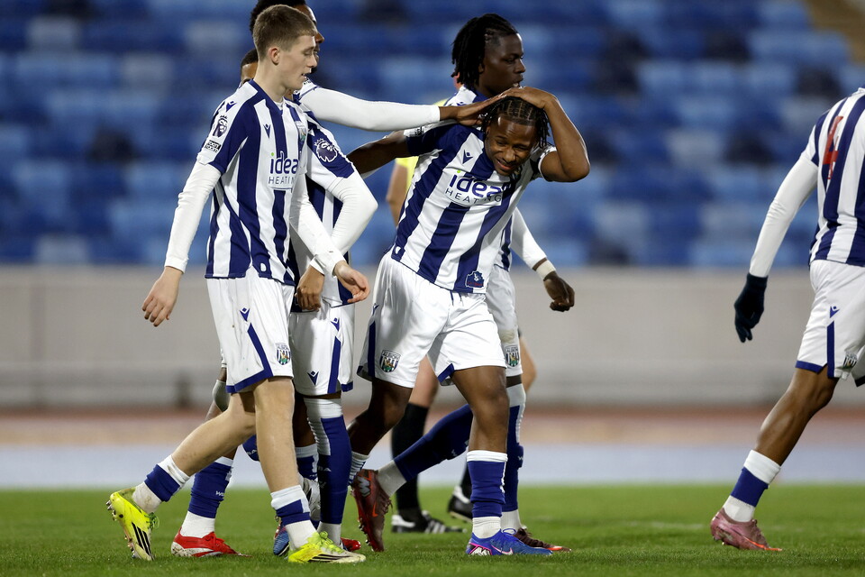 Remar McNeil celebrates with team-mates following a goal in the home kit 