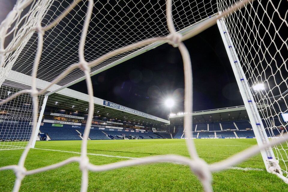 A general view of The Hawthorns at night through the goal net in front of the Smethwick End 