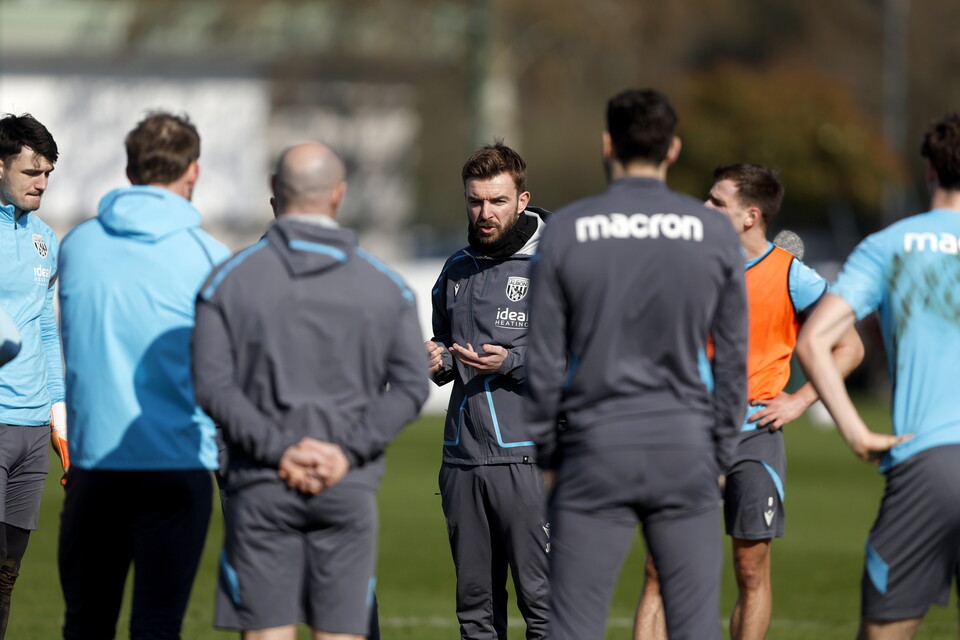 James Morrison talking to a group of staff and players on the training pitch