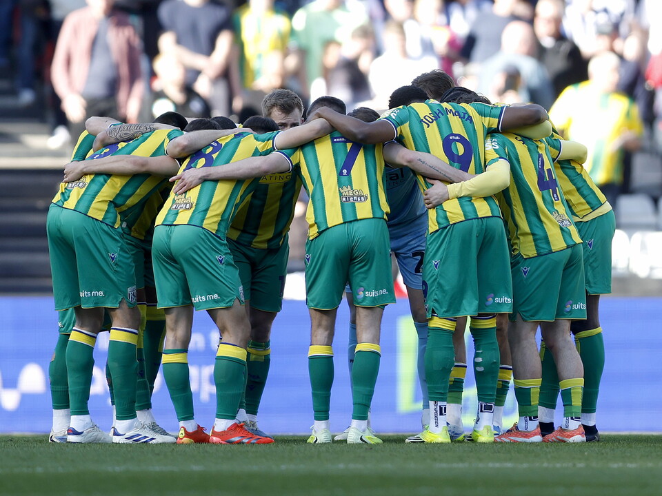 WBA players in a pre-match huddle before the Bristol City game in the green and yellow away kit 