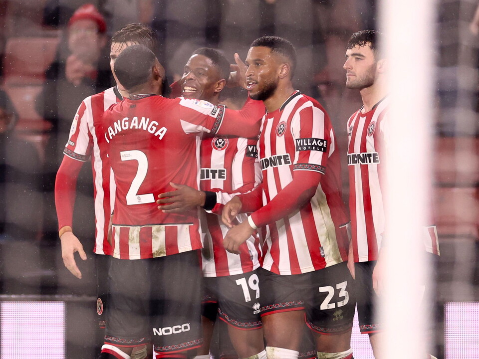Sheffield United players celebrating a goal in their home kit 
