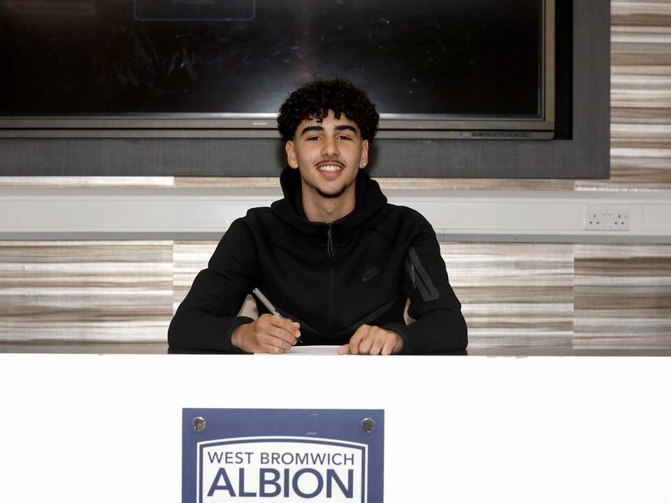 A photo of youngster Adam Letlat signing his first pro deal