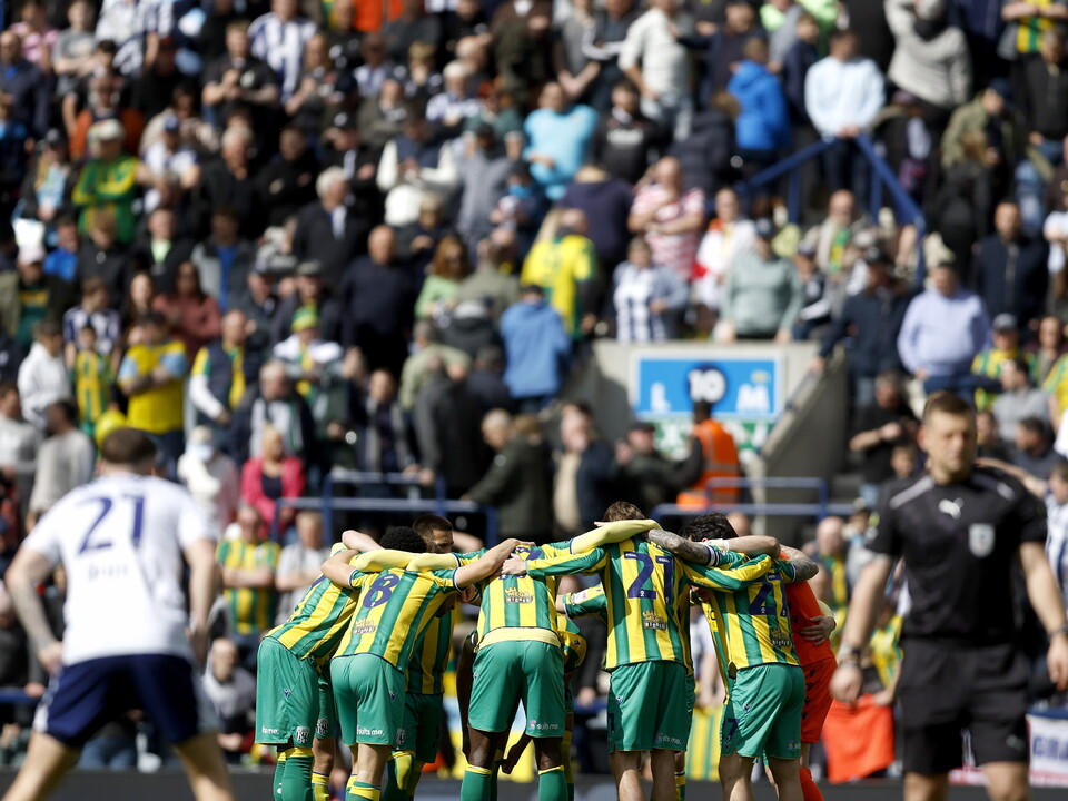 An image of Albion's starting XI in a huddle in front of 4,000 travelling fans