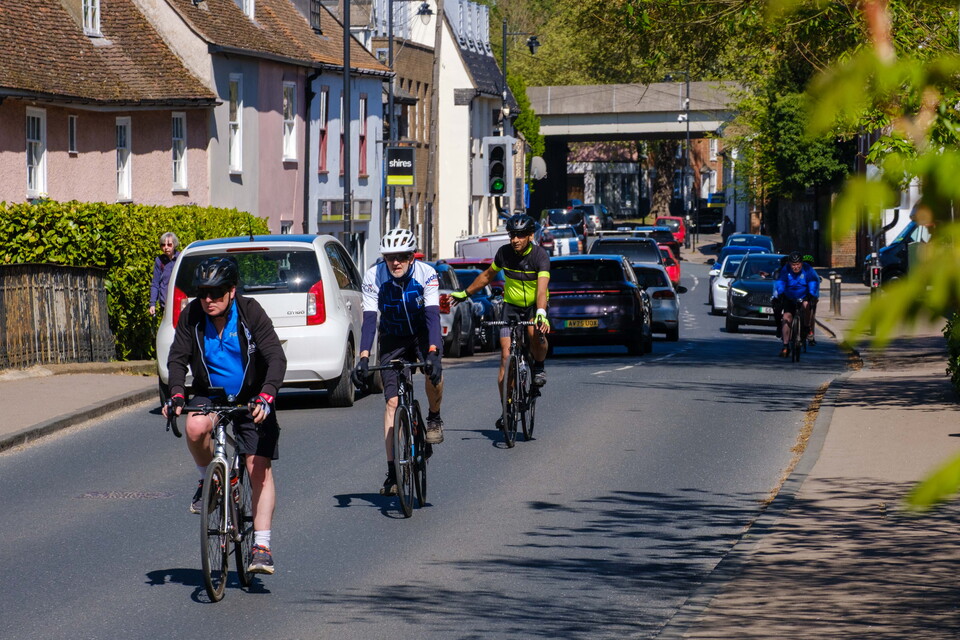 Cyclists riding down a residential road.
