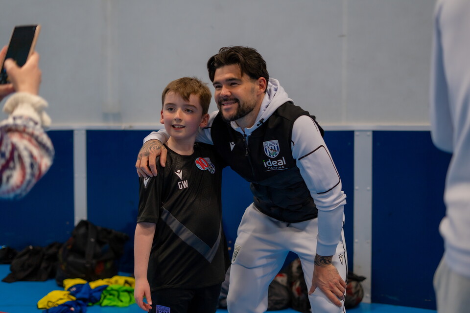 Mowatt taking a photo with a young PAN Football participant.