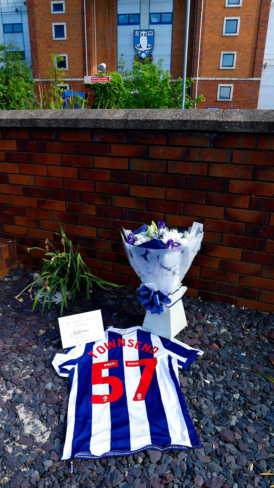An Albion shirt with Townsend 57 on the back, as well as flowers and a signed card on the fans memorial outside Hillsborough
