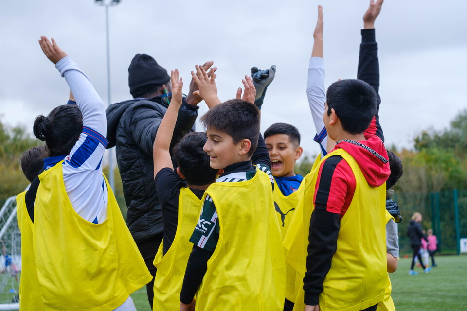 Group of participants with hands raised after a team huddle.