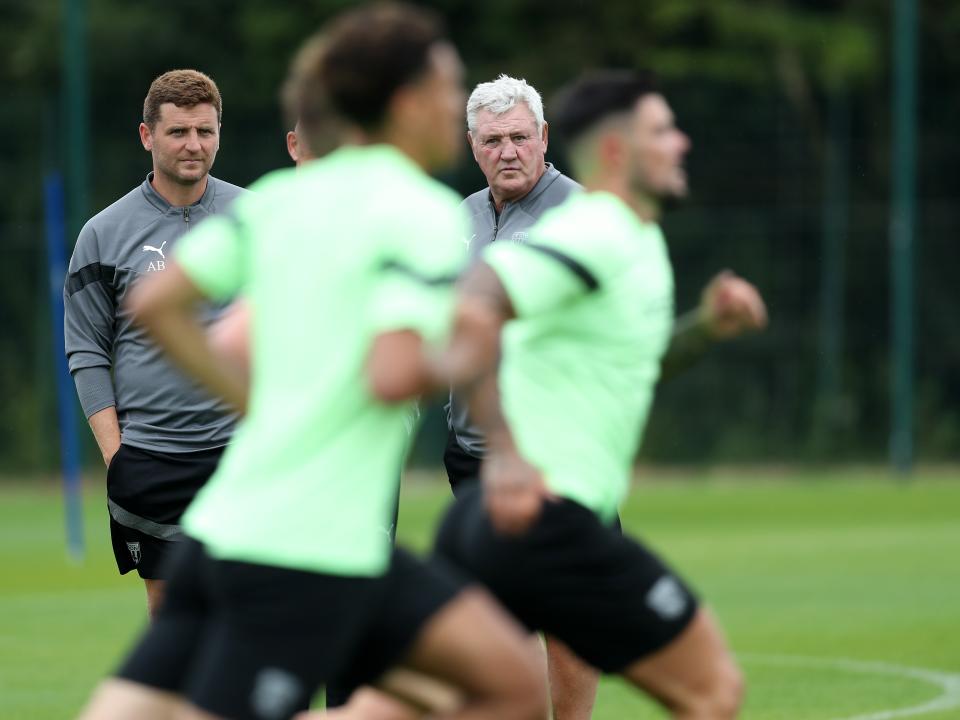 Albion players train as Steve Bruce looks on.