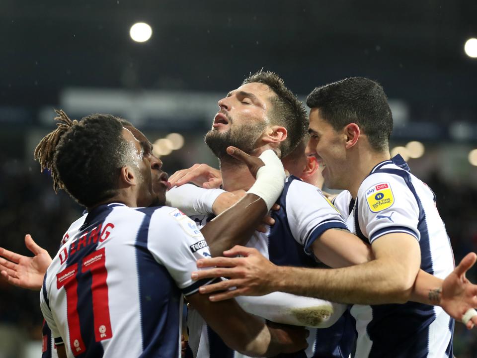 Okay Yokuslu is congratulated by his team-mates after scoring against Blackpool