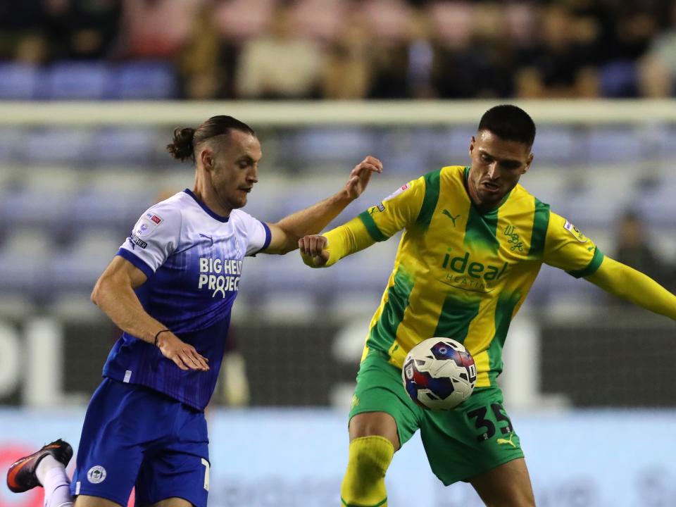 Okay Yokuslu battles for the ball with a Wigan player