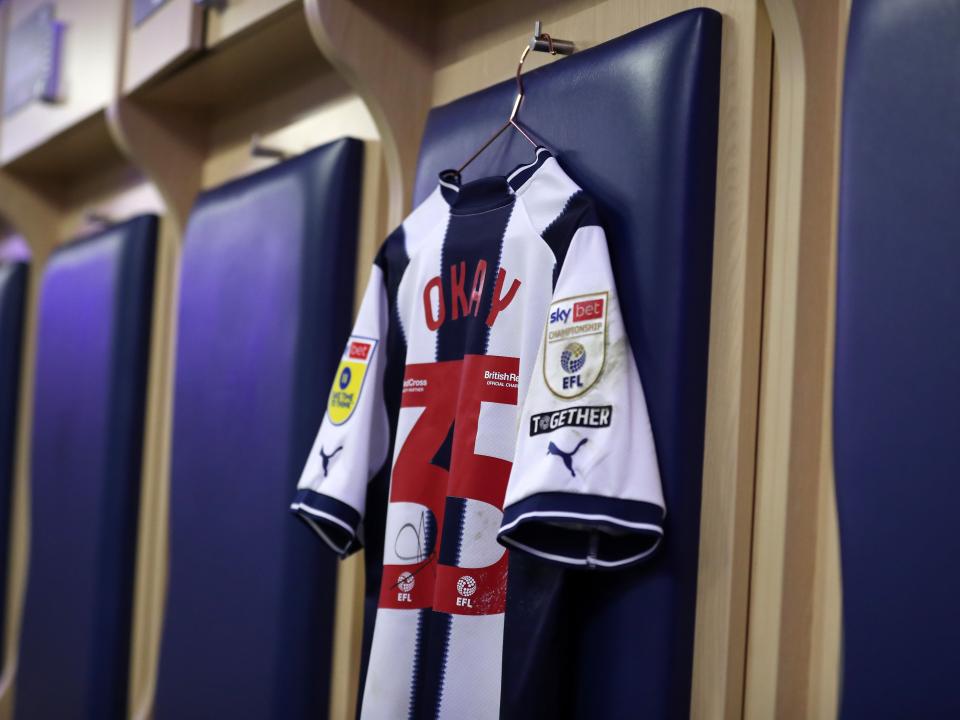 An image of a signed Okay Yokuslu shirt hanging in the dressing room