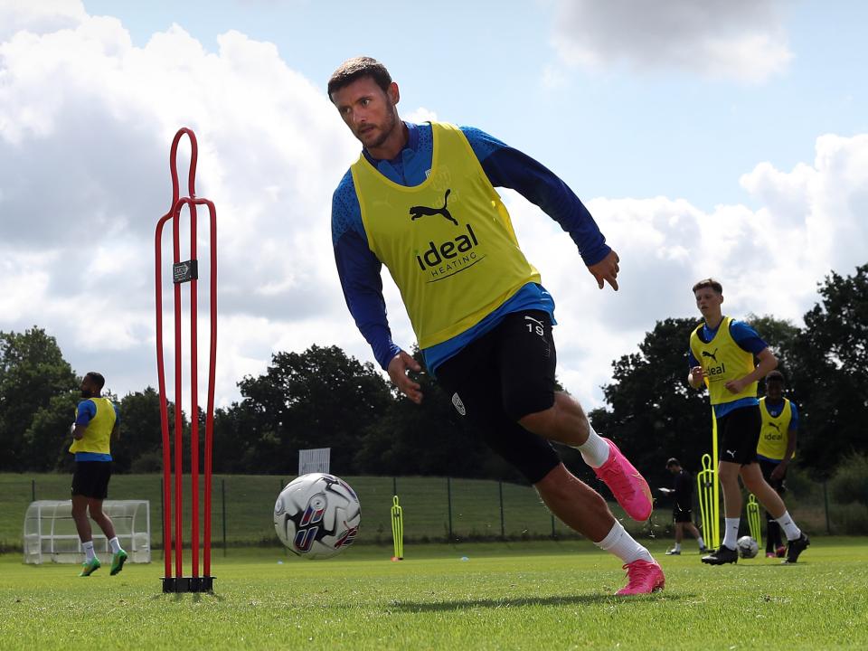 John Swift on the ball in pre-season training in a yellow bib