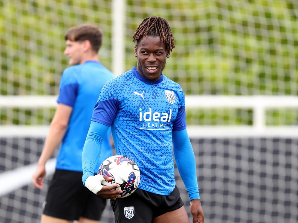 Brandon Thomas-Asante holding a football during training at St. George's Park