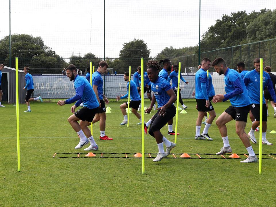 Albion players run through poles during the warm-up in training 