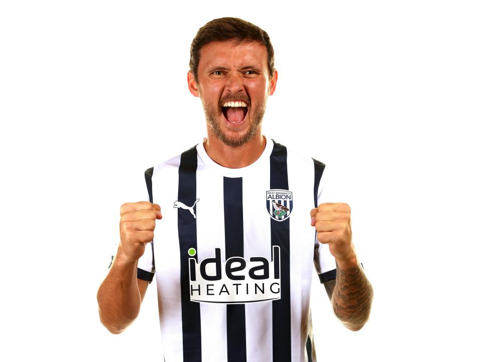 John Swift posing for a photo cheering with his fists clenched 