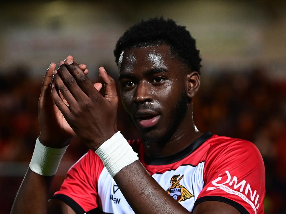 Mo Faal wearing a Doncaster shirt applauding their supporters 