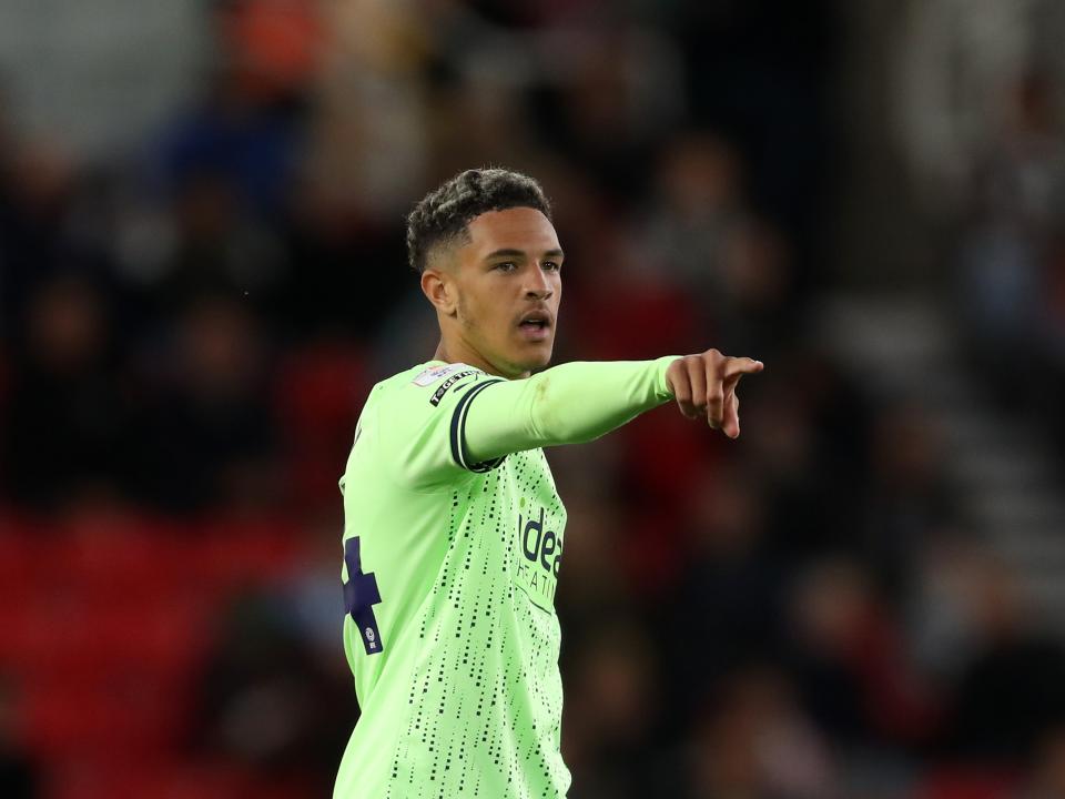 Ethan Ingram pointing forwards in the green away kit