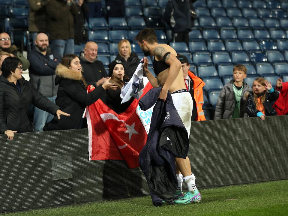 Okay Yokuslu chats with supporters who have a Turkey flag