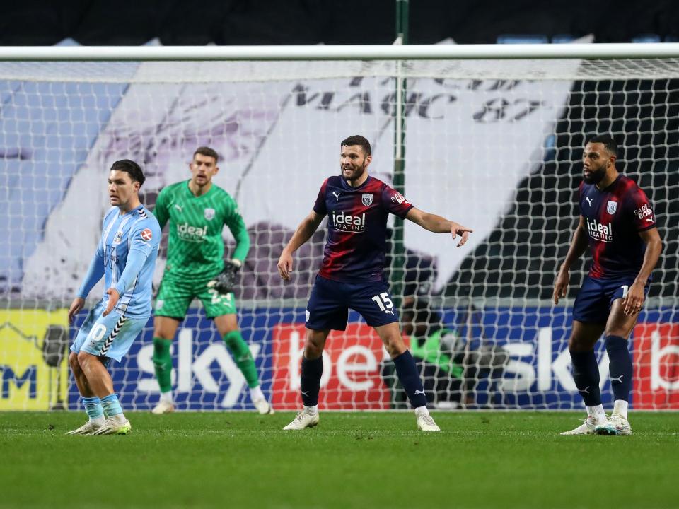 Erik Pieters pointing to his left with Matty Phillips to his left and a Coventry player to the right
