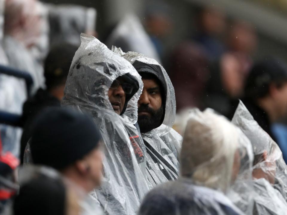 Two Albion fans stood in raincoats