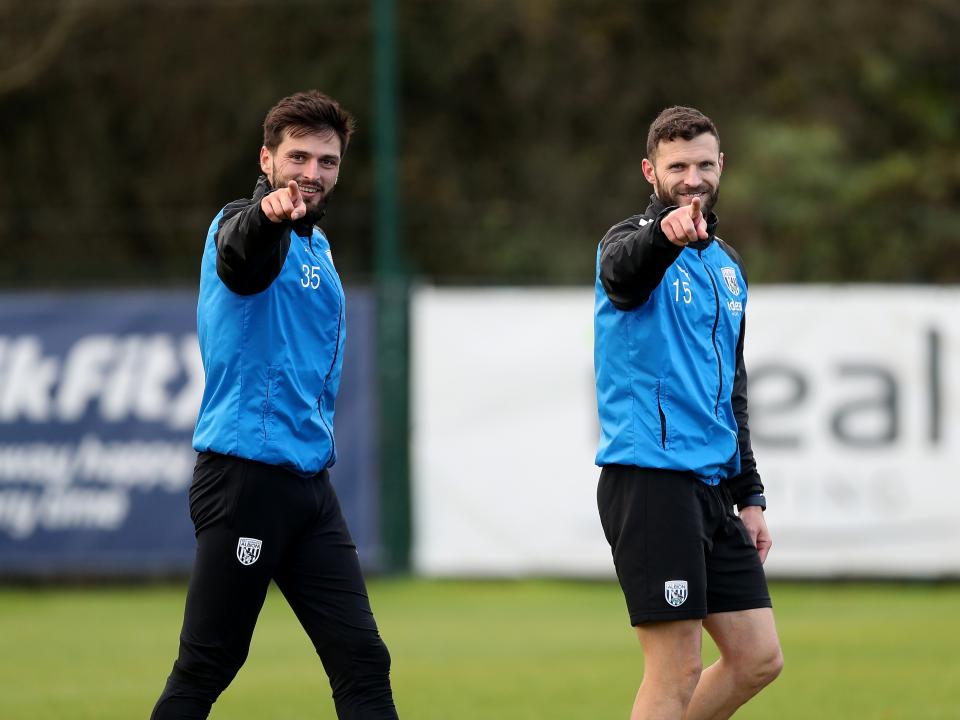 Okay Yokuslu and Erik Pieters pointing and smiling directly towards the camera