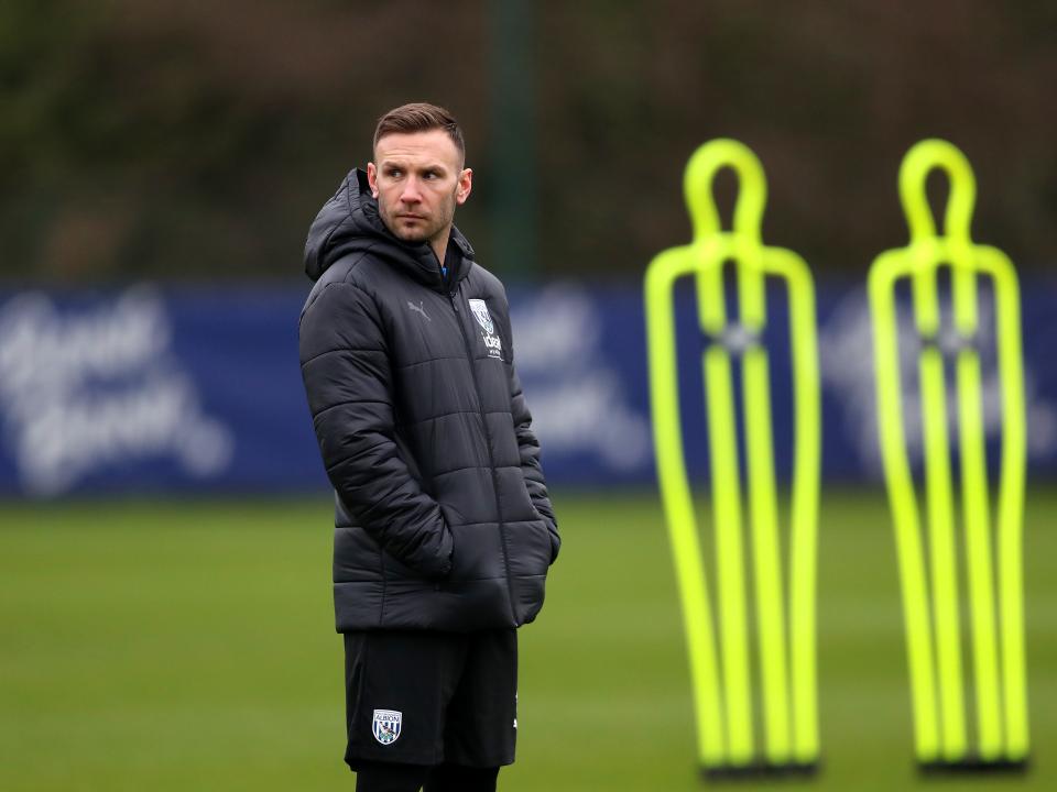 Andi Weimann watching training in a black coat