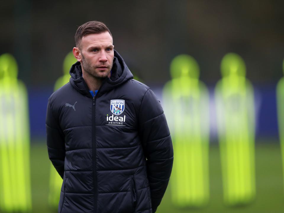 Andi Weimann watching training in a black coat