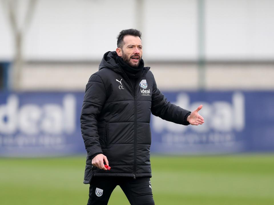 Carlos Corberán in a black coat during a training session
