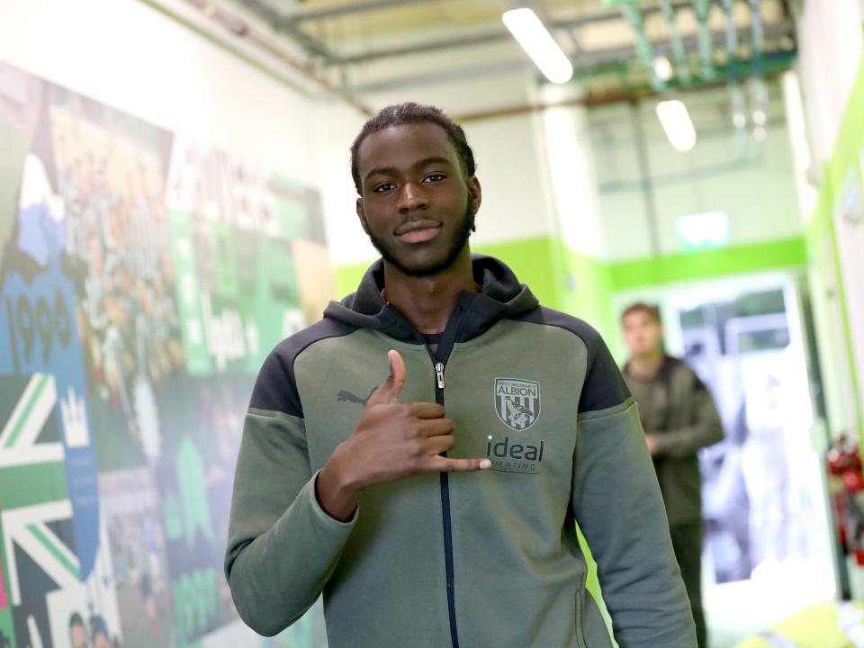Mo Faal posing for a photo while arriving for an Albion game in a matchday tracksuit