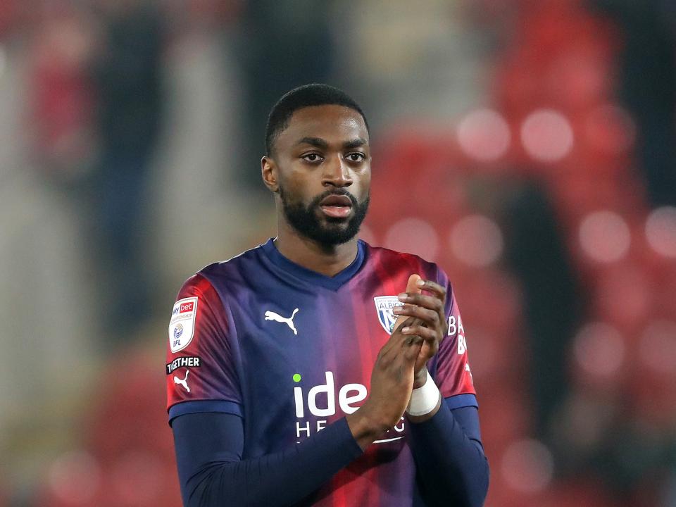 Semi Ajayi applauding Albion fans wearing the navy blue and red away kit