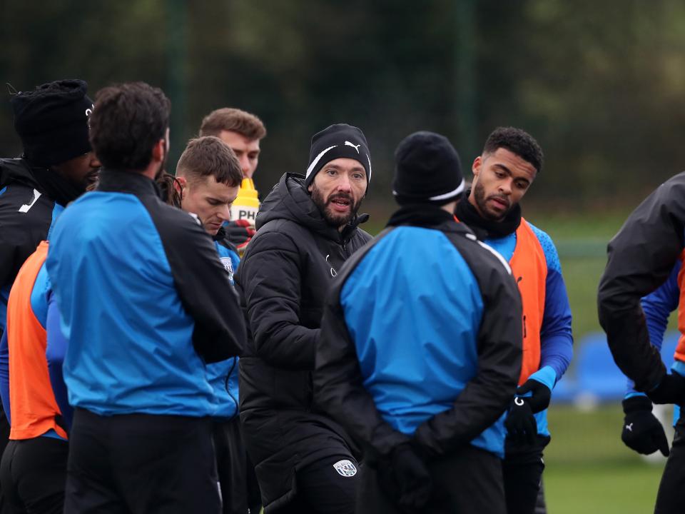 Carlos Corberán delivering a speech in the middle of a training session surrounded by members of his squad