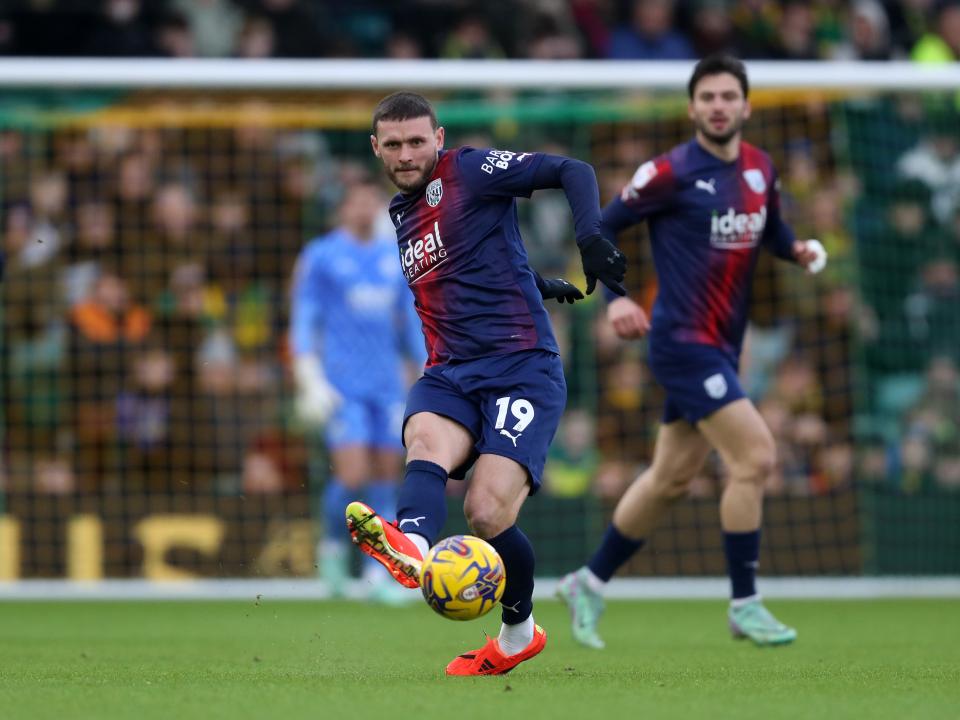 An image of John Swift playing a pass against Norwich