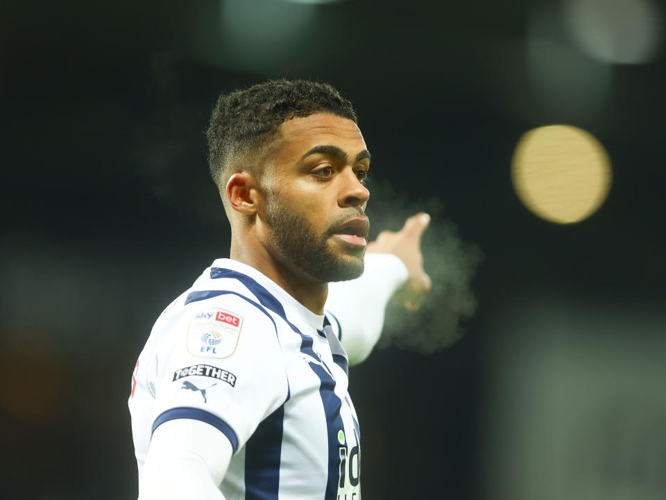 Darnell Furlong pointing to his left while wearing a home shirt
