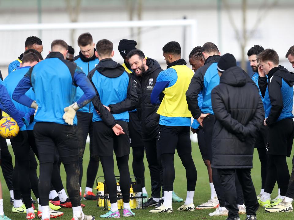 Carlos Corberán delivering instructions to several players during a training session