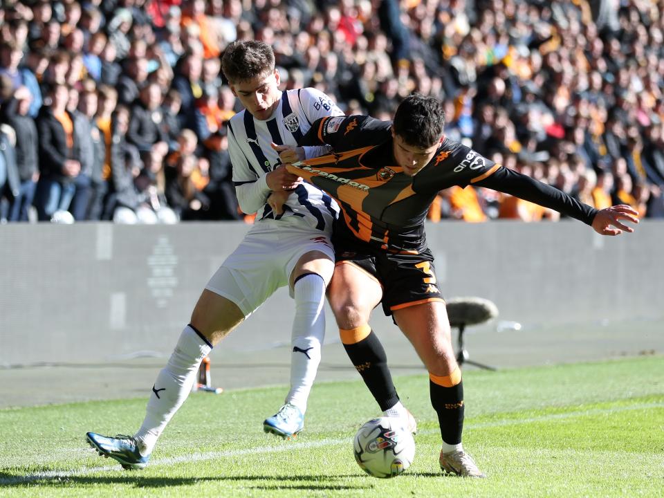 Tom Fellows battles for the ball with a Hull City player
