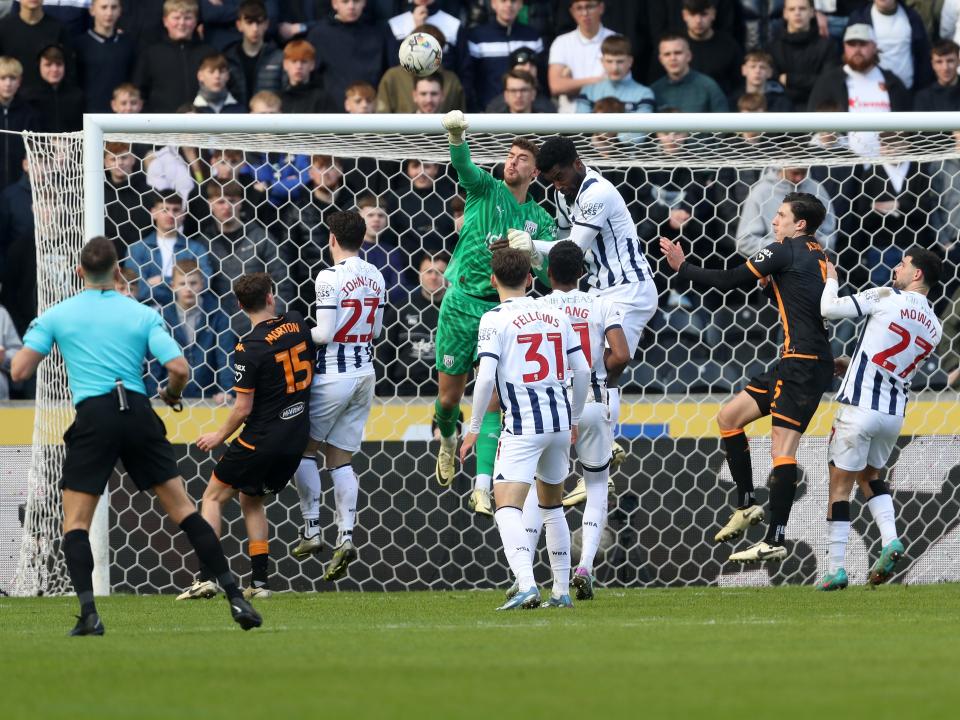 Alex Palmer punches the ball clear with several Hull and Albion players around him