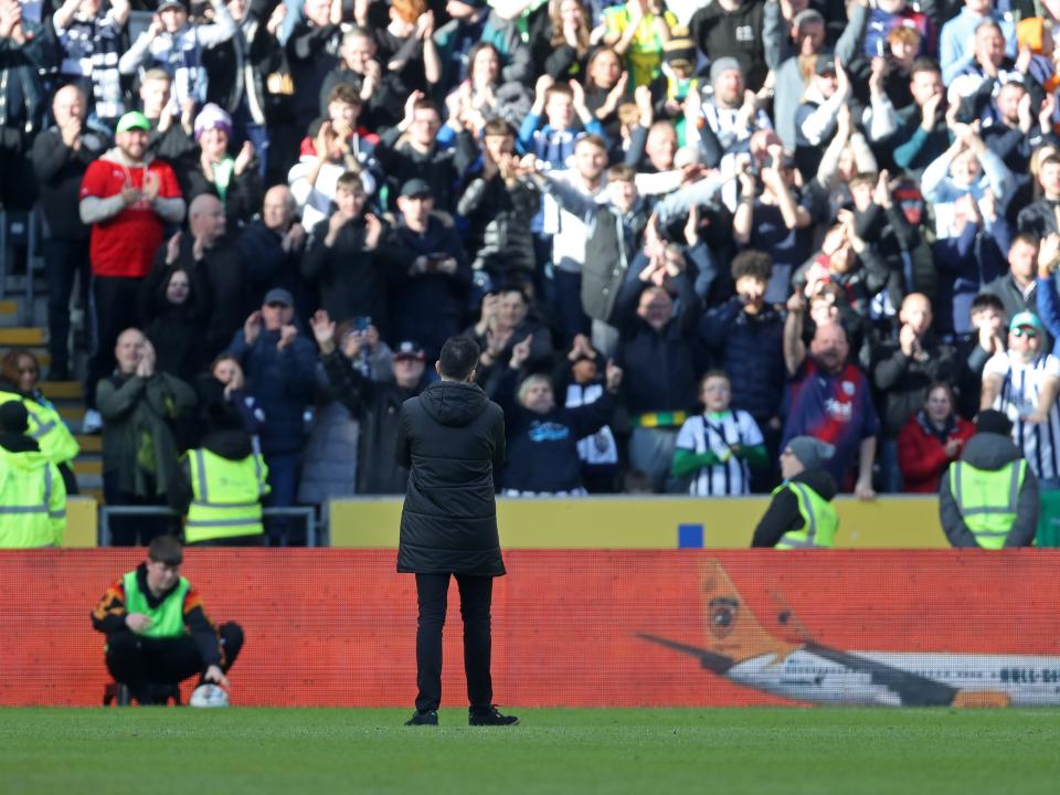 Carlos Corberán applauding Albion fans in the background at the MKM Stadium