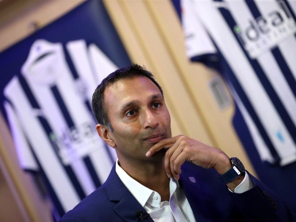Shilen Patel is interviewed by WBA TV in the home dressing room with Albion shirts hanging behind him