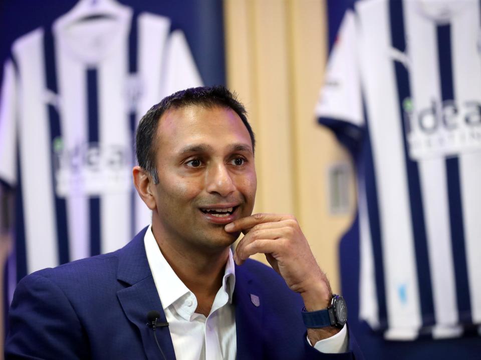 Shilen Patel is interviewed by WBA TV in the home dressing room with Albion shirts hanging behind him