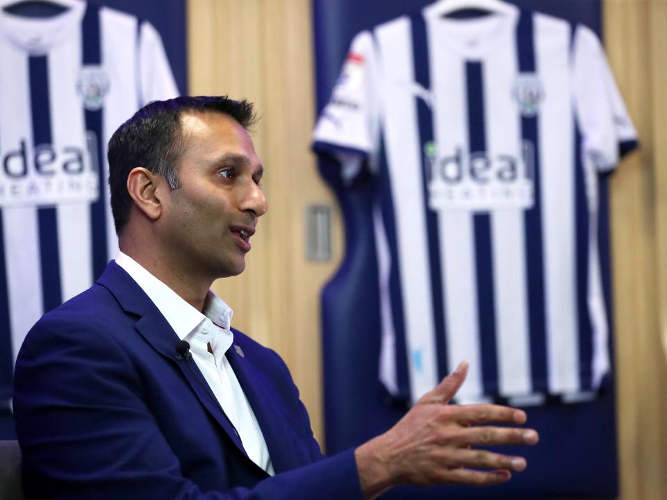 Shilen Patel is interviewed by WBA TV in the home dressing room with Albion shirts hanging behind him
