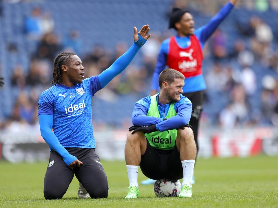 Brandon Thomas-Asante points to his left smiling at The Hawthorns during a training session