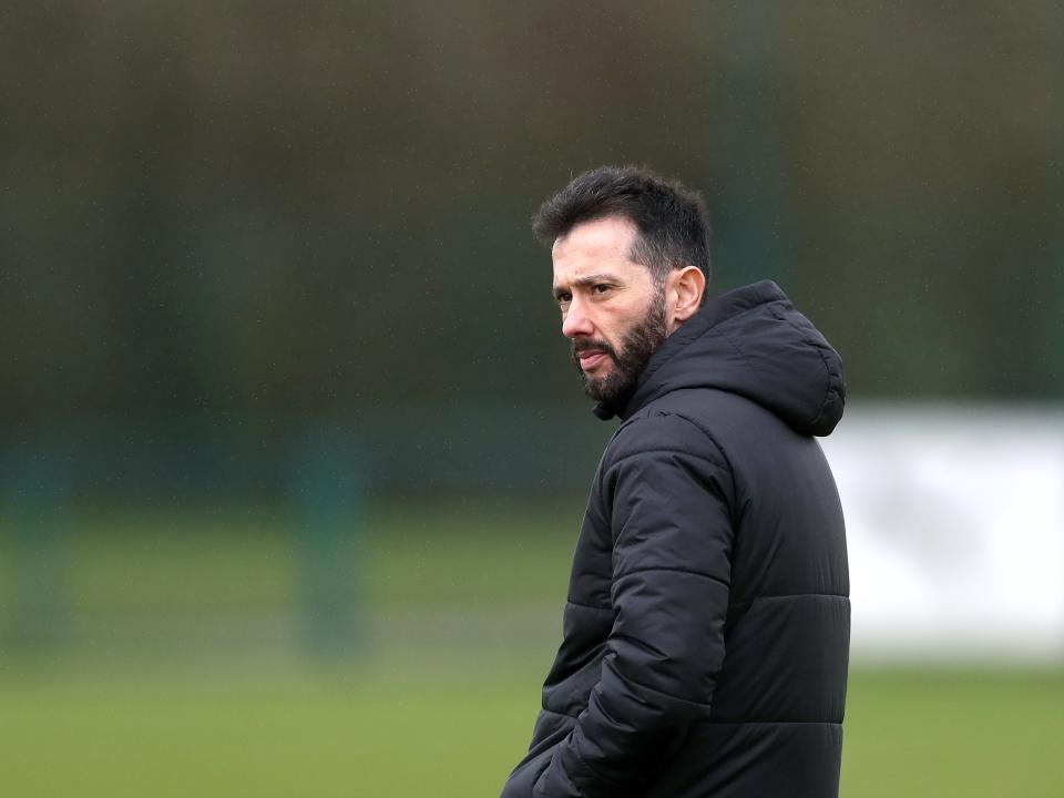 Carlos Corberán wearing a black coat while watching a training session