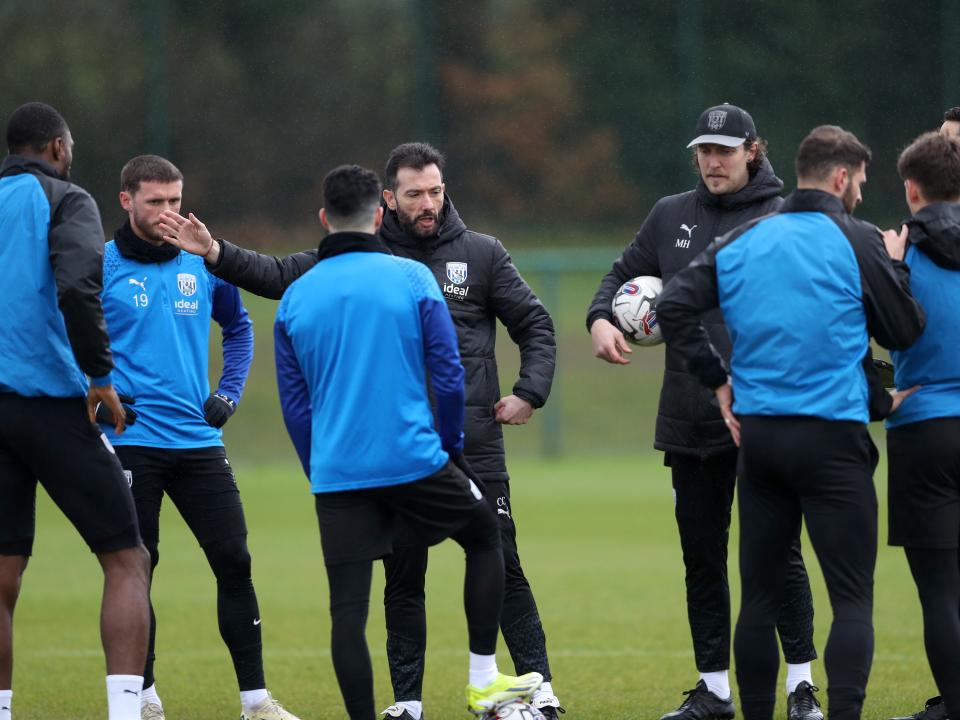 Carlos Corberán delivering a message to several members of his squad out on the training pitch