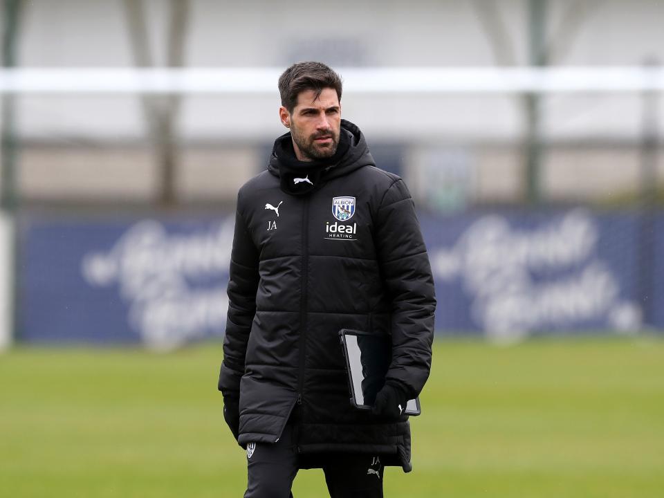 Jorge Alarcon wearing a black coat holding a notepad out on the training pitch