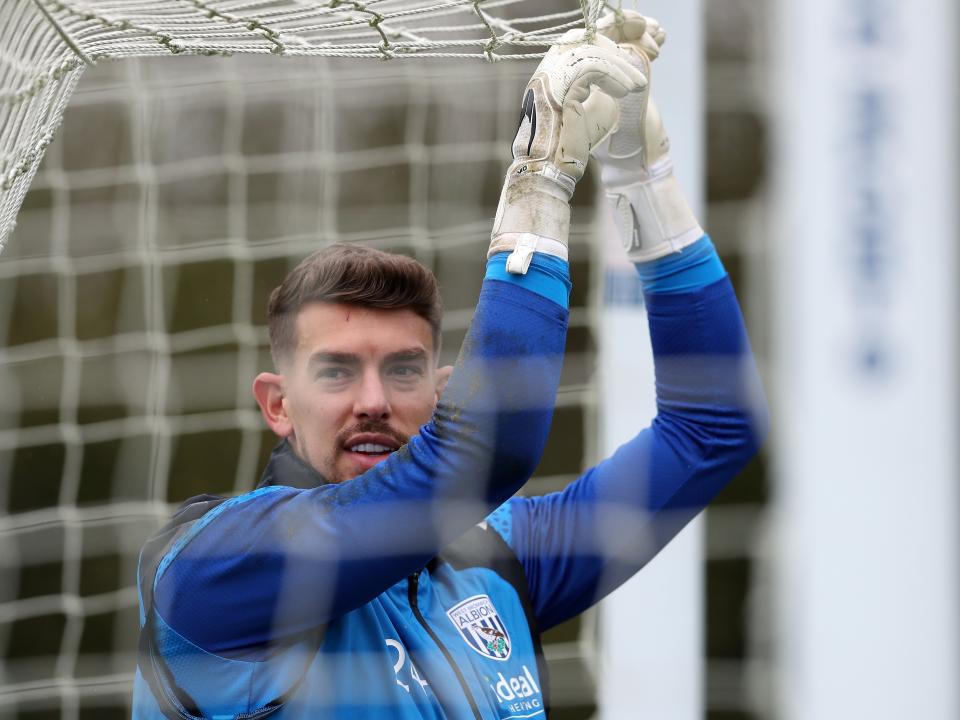 Alex Palmer hanging on to a goal net during a training session